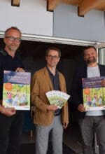 Pflegedirektor Thomas Linnemann, der Ärztliche Direktor Prof. Dr. Dr. Martin Holtmann und der Kaufmännische Direktor Dr. Daniel Napieralski-Rahn (v. li.) freuen sich, endlich wieder zum "Tag der offenen Tür" auf das Gelände der LWL-Universitätsklinik für Kinder- und Jugendpsy-chiatrie einladen zu dürfen. Vor der "Arche", dem Neubau für die begleitende tiergestützte Therapie, präsentieren sie Plakate und Flyer. Foto - LWL
