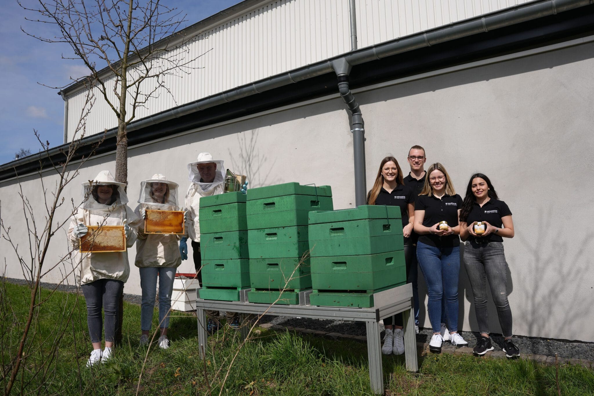 Das Azubi-Team, das am Mennekes-Logistikzentrum die Bienen betreut präsentiert u.a. Gläser des Honigs 2022 - MENNEKES / Foto Remo Wutta