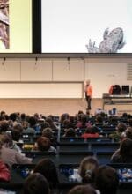 Voller Hörsaal am Campus Unteres Schloss: Prof. Dr. Klaudia Witte erklärt in einer Kinderuni-Vorlesung, wie sich Tiere in der Natur tarnen - Foto Universität Siegen