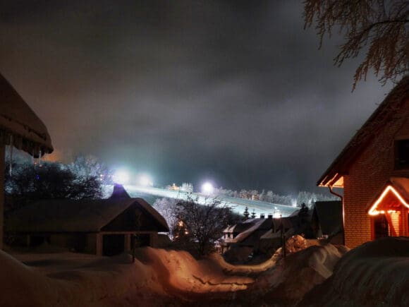 Blick aufs Skidorf Neuastenberg, dort lässt sich Silvester Skifahren unter Flutlicht und ins neue Jahr feiern miteinander verbinden - Foto postwiese.de